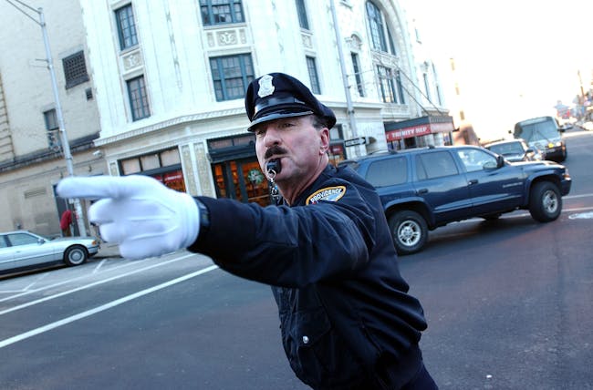 PROVIDENCE, RI - DECEMBER 14: Retired police officer Tony Lepore performs his dance routine while directing traffic December 14, 2004 in downtown Providence, Rhode Island. Lepore has been entertaining drivers and directing traffic at intersections around Providence for 20 years. He came upon the idea after seeing a 'Candid Camera' clip of New York City police officers who flamboyantly directed traffic in the 1950's. (Photo by Darren McCollester/Getty Images)