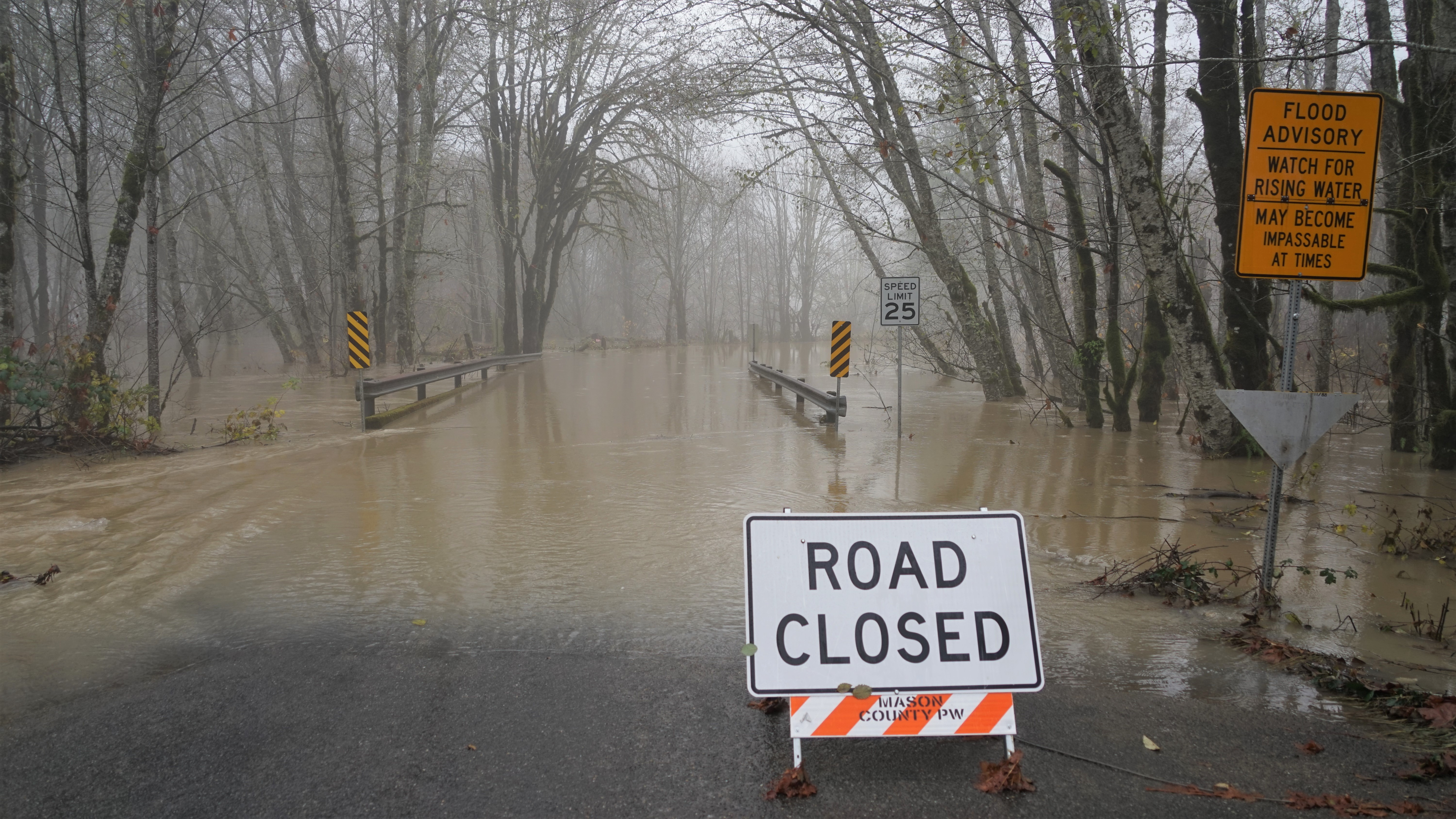 road closed sign in front of a flooded street
