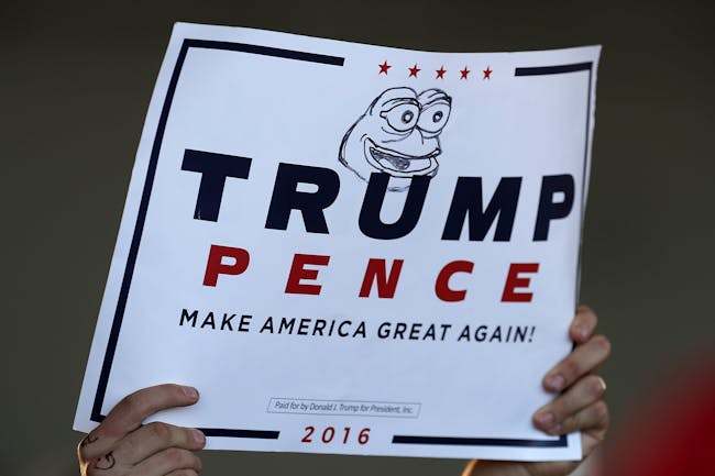 MINNEAPOLIS, MN - NOVEMBER 06: A supporter holds a campaign sign for Republican presidential nominee Donald Trump with 'Pepe the Frog' drawn on it during a rally in the Sun Country Airlines Hangar at MinneapolisÐSaint Paul International Airport November 6, 2016 in Minneapolis, Minnesota. With less than 48 hours until Election Day in the United States, Trump and his opponent, Democratic presidential nominee Hillary Clinton, are campaigning in key battleground states that each must win to take the White House. (Photo by Chip Somodevilla/Getty Images)