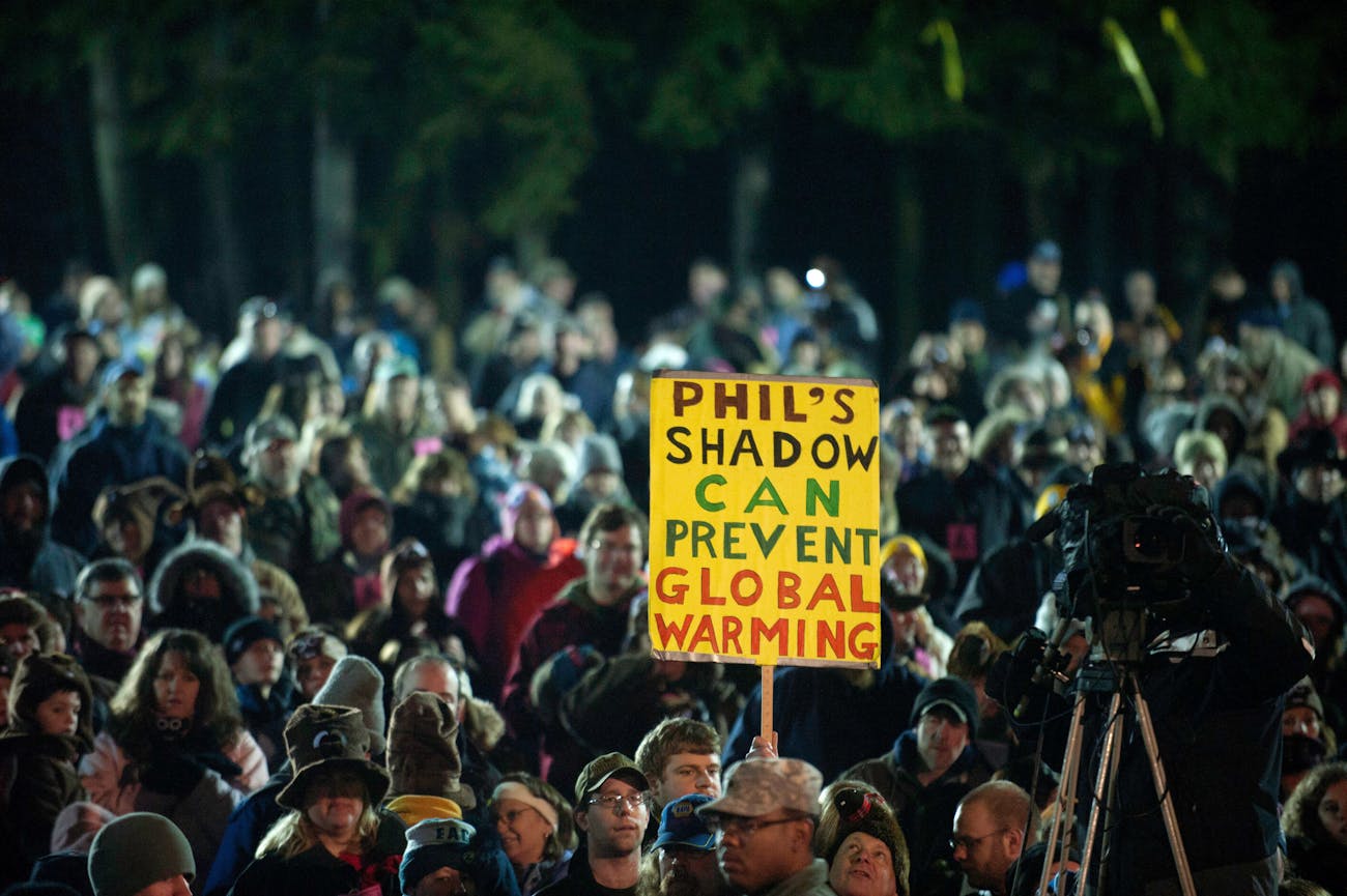 PUNXSUTAWNEY, PA - FEBRUARY 2: The crowd wait for Punxsutawney Phil to come from his den on the 126th annual Groundhog Day festivities on February 2, 2012 in Punxsutawney, Pennsylvania. The groundhog saw his shadow, revealing that there would be 6 more weeks of winter. Groundhog Day is a popular tradition in the United States and Canada. A smaller than usual crowd this year of less than 18,000 people spent a night of revelry awaiting the sunrise and the groundhog's exit from his winter den. If Punxsutawney Phil sees his shadow he regards it as an omen of six more weeks of bad weather and returns to his den. Early spring arrives if he does not see his shadow, causing Phil to remain above ground. (Photo by Jeff Swensen/Getty Images)