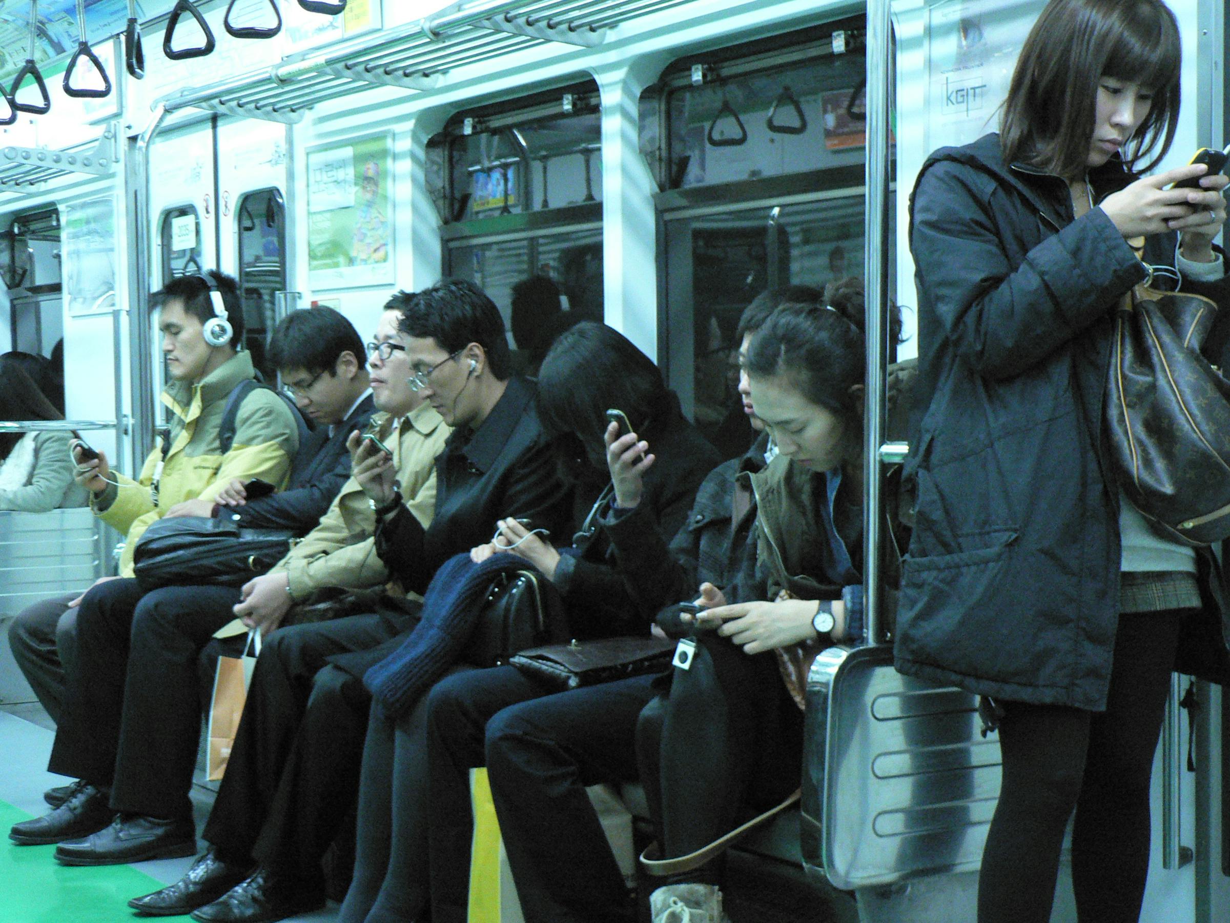 Everyone is staring at their phone, on the Seoul Metro, Seoul, Korea November 2010