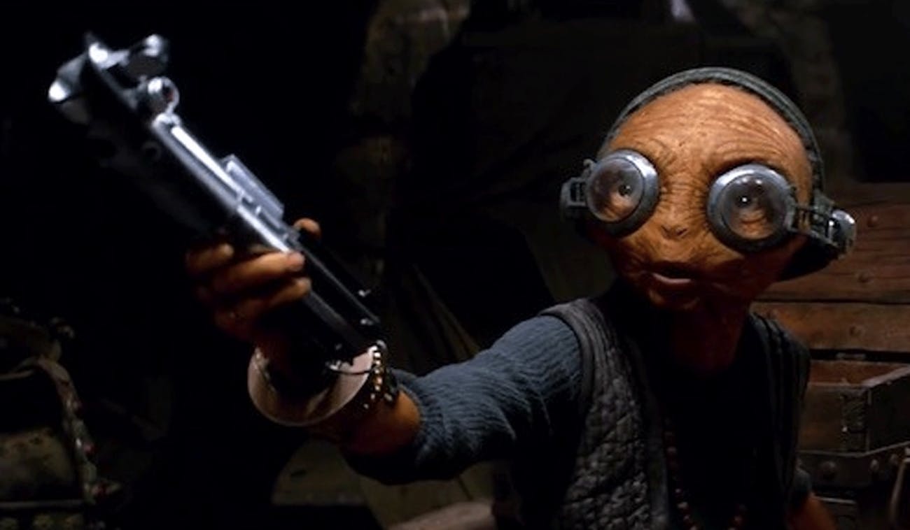 Maz Kanata offers Luke Skywalker's old lightsaber to Rey.