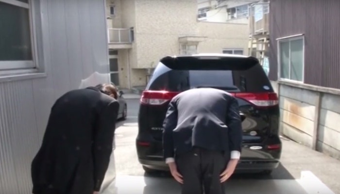 Members of the staff bowing as they say goodbye to one of their guests