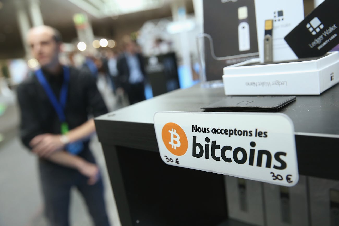 HANOVER, GERMANY - MARCH 16: A sign in French that reads: 'We accept bitcoins' hangs at a display of the LedgerWallet Nano USB stick that enables security-protected transactions with bitcoins at the 2015 CeBIT technology trade fair on March 16, 2015 in Hanover, Germany. China is this year's CeBIT partner. CeBIT is the world's largest tech fair and will be open from March 16 through March 20. (Photo by Sean Gallup/Getty Images)