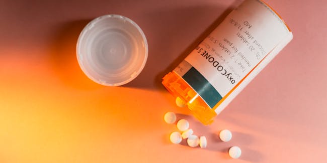 Oxycodone Prescription Bottle with Pills Spilling Out.