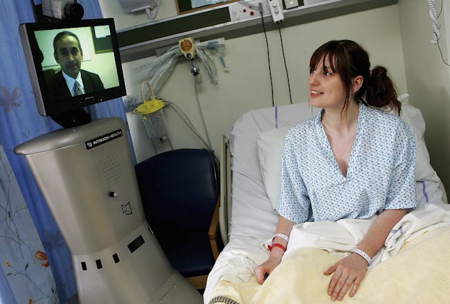 A member of the St Mary's Hospital medical staff operates the Sister Mary RP6 (Remote Presence Robot), as he communicates with a patient via a remote console system in London, England.