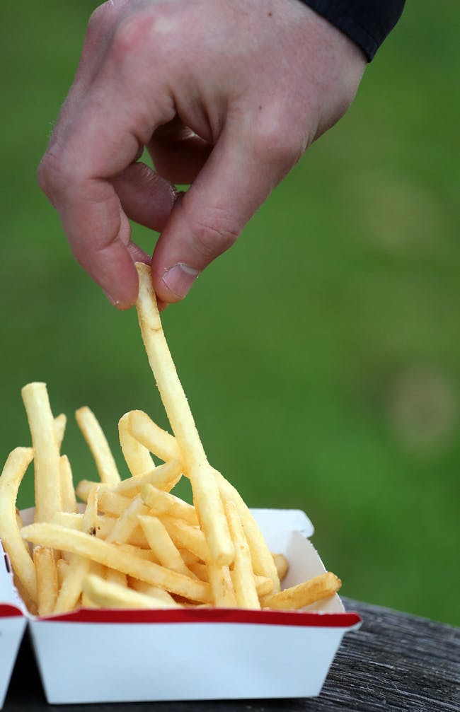 BRISTOL, ENGLAND - JANUARY 07: In this photo-illustration a man eats French fries purchased from a fast food outlet on January 7, 2013 in Bristol, England. A government-backed TV advert - made by Aardman, the creators of Wallace and Gromit - to promote healthy eating in England, is to be shown for the first time later today. England has one of the highest rates of obesity in Europe - costing the NHS 5 billion GDP each year - with currently over 60 percent of adults and a third of 10 and 11 year olds thought to be overweight or obese. (Photo by Matt Cardy/Getty Images)