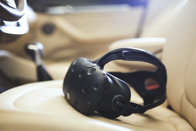 The HTC Vive headset resting on a car seat.