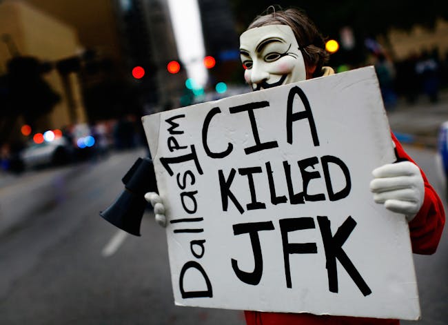 DALLAS, TX - NOVEMBER 22: A lone protester stands outside the John F. Kennedy Memorial Plaza on November 22, 2013 in Dallas, Texas. Visitors streamed through the memorial on the 50th anniversary of the assassination of U.S. President John F. Kennedy as he rode in a Presidential motorcade in Dealey Plaza. (Photo by Tom Pennington/Getty Images)