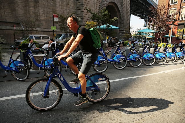 A man rides a bike through Dumbo on October 4, 2013 in the Brooklyn borough of New York City. A group of five prominent properties in Dumbo owned by the Jehovah's Witnesses have recently been sold and are slated to become part of a complex that will be converted into a center for technology companies. The five buildings, which will become part of the larger Brooklyn Tech Triangle, were sold to Jared Kushner, the Kushner Cos. CEO, and RFR for a reported $375 million deal. What was until recently a sleepy former manufacturing hub with cobblestone streets and derelict old factories has become one of the trendiest locations in New York City.