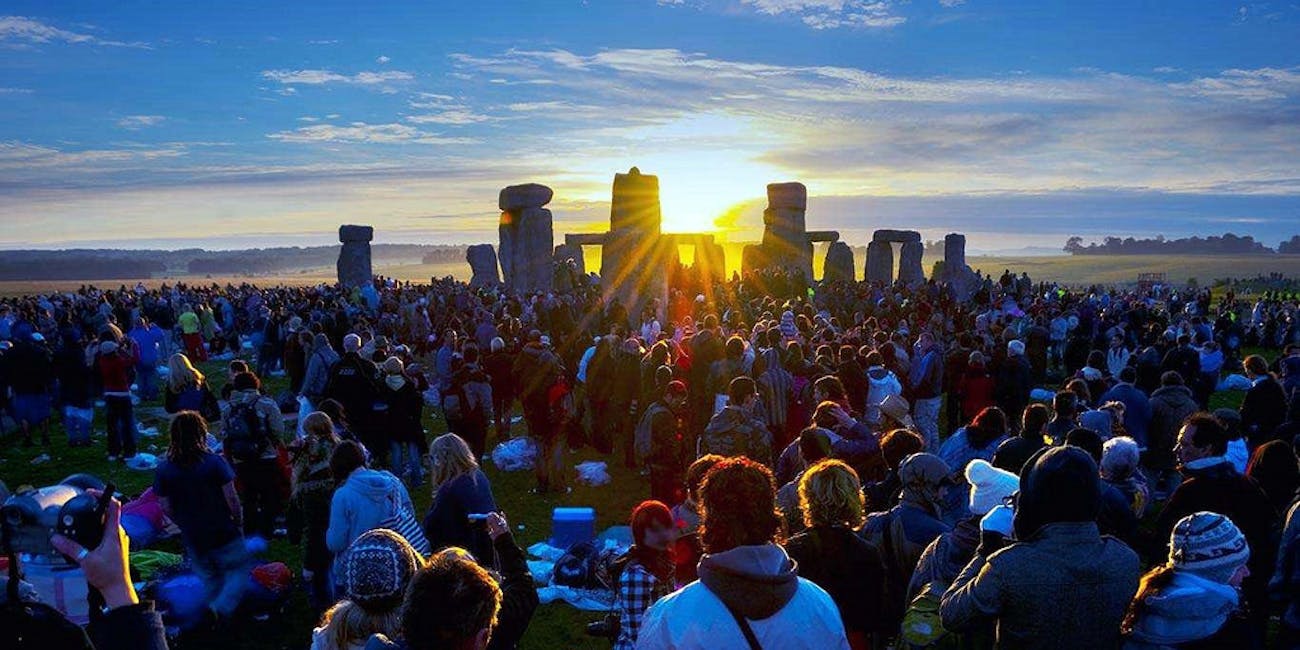Revelers watch the Solstice Sun rise over Stonehenge Heel Stone