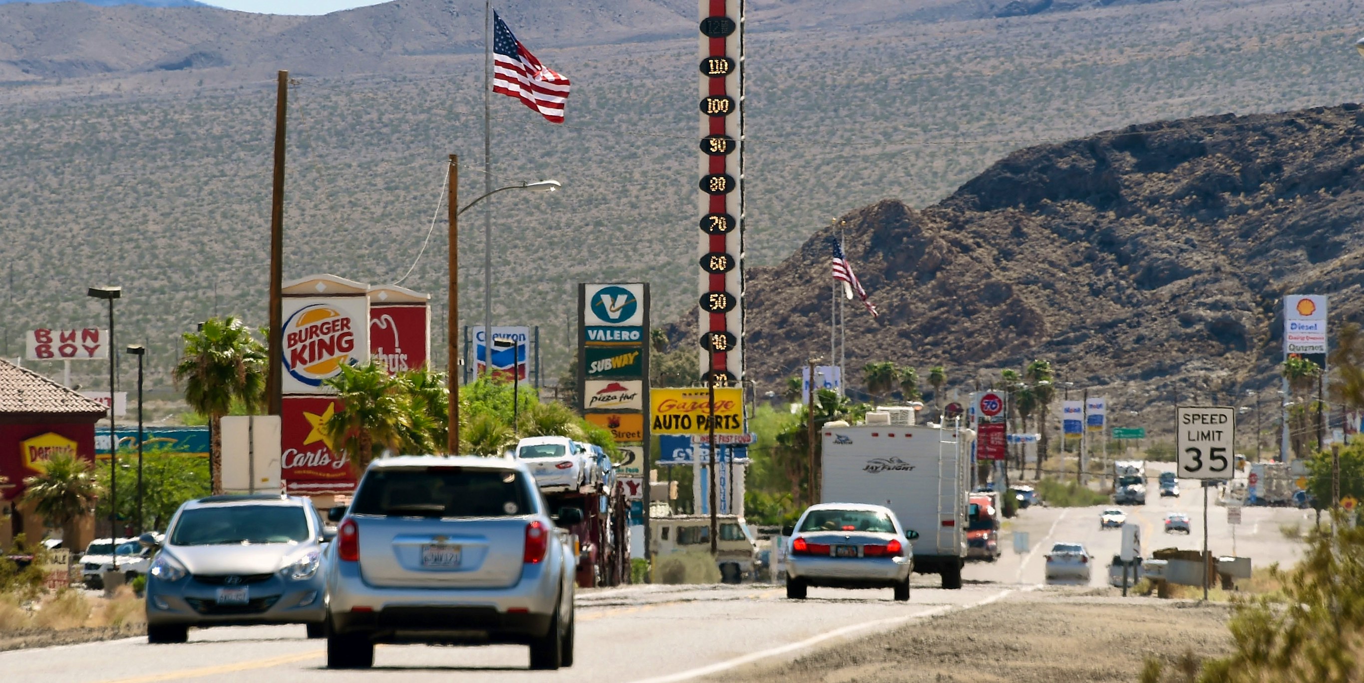 Vehicles drive by a 134-foot-high electronic sign displaying a temperature of 110 degrees Fahrenheit on July 23, 2014 in Baker, California.